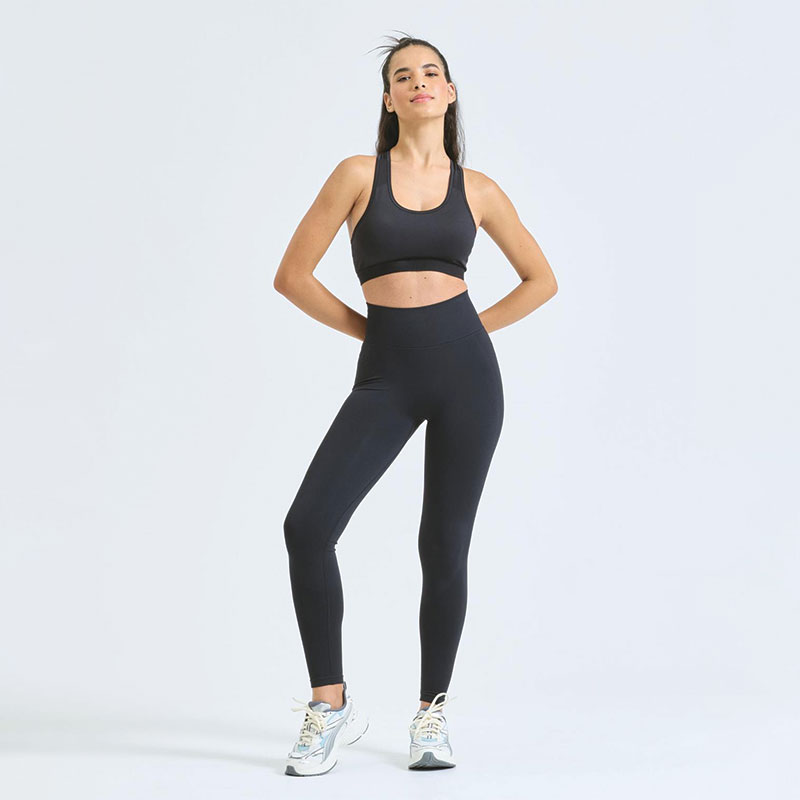 Woman wearing black high-waisted scrunch leggings with sports bra, full body gym activewear outfit.